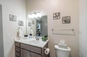 Un baño con lavabo, inodoro y espejo. en Stylish Studio with Free Parking Near Medical District, en Louisville