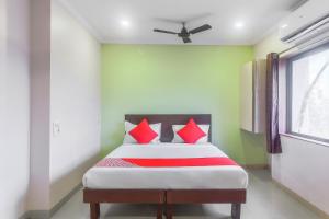 a bedroom with a bed with red pillows on it at Hotel O Gokul Residency in Kharadi +21 photos