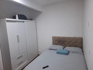 a small bedroom with a bed and a white cabinet at Casa espaçosa bem localizada in Belém
