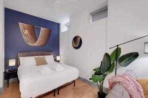 Un dormitorio con una cama blanca y una pared azul. en 8 Unit Cozy & Bright Loft with Free Parking, en Louisville 67 fotos más