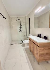 a bathroom with a sink and a shower and a toilet at GK Luxury Suites in Alexandroupoli