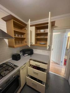 a kitchen with white cabinets and a stove top oven at Gatwick 1 Bedroom Apartment in Chipstead