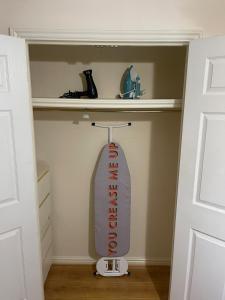 a locker room with a surfboard in a closet at Gatwick 1 Bedroom Apartment in Chipstead