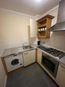 a small kitchen with a stove and a sink at Gatwick 1 Bedroom Apartment in Chipstead +7 photos