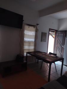 a living room with a table and a window at Casa de praia sertãozinho in São Sebastião