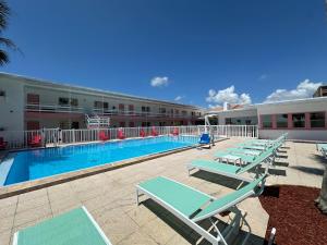 a swimming pool with lounge chairs and a hotel at Arvilla Resort in St Pete Beach
