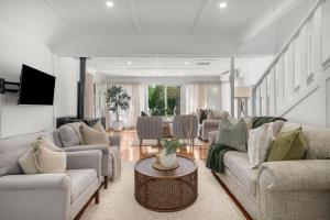 un salon avec des canapés et une table dans l'établissement Lavender Cottage Alpine Southern Highlands, à Alpine