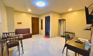 a living room with a couch and a table and chairs at Algers Suites in Manila