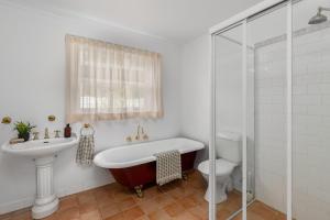 a bathroom with a tub and a sink and a toilet at Pottery Cottage, Alpine, Southern Highlands in Alpine +10 photos