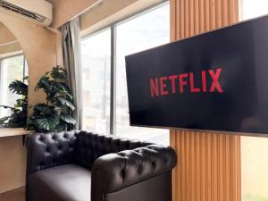 アンヘレスにあるGoodnews Innのソファの横の壁にNetflixと書かれた看板