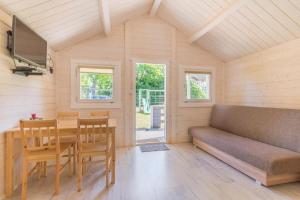 a living room with a couch and a table and chairs at Holiday Home Dziwnówek near Baltic Sea in Dziwnówek