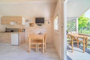 a kitchen and dining room with a table and chairs at Holiday Home Dziwnówek near Baltic Sea in Dziwnówek