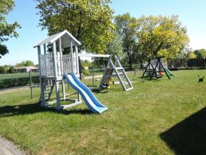 a playground with a slide in the grass at Holiday Home Dziwnówek near Baltic Sea in Dziwnówek