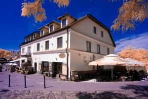 un grand bâtiment blanc avec des parasols en face de celui-ci dans l'établissement Apartamenty "Starówka", à Kazimierz Dolny