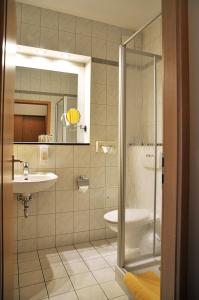 a bathroom with a shower and a sink and a toilet at Hotel Friesen in Werdau