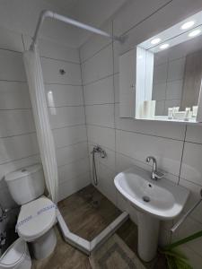 a white bathroom with a toilet and a sink at Luxury Angel Apartments 3 in Paralia Katerinis +17 photos