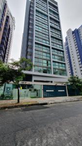 ein hohes Gebäude mit einem Baum davor in der Unterkunft Rooftop 470 #Flat 1005 - Boa Viagem in Recife