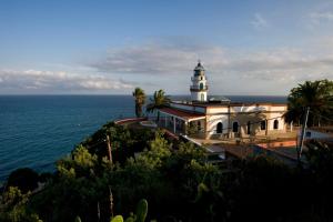 a lighthouse on top of a hill next to the ocean at Raco d'en Pepe in Calella