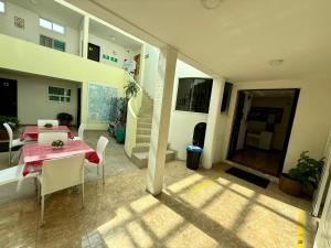 a dining room with a red table and white chairs at Hotel Arbis in Puebla