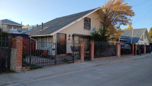 a house with a fence on a street at Iris in Punta Arenas