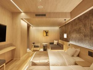 a hotel room with a bed and a couch at One Station Hotel Kumamoto -DLIGHT LIFE & HOTELS- in Kumamoto