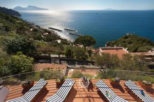 - szereg leżaków na balkonie z widokiem na ocean w obiekcie Villa Oleandro w mieście Massa Lubrense