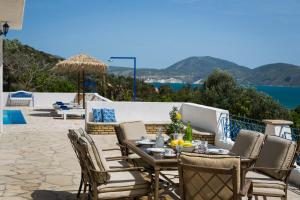 a table and chairs on a patio with a view of the ocean at Villa Afrodite in Lixouri