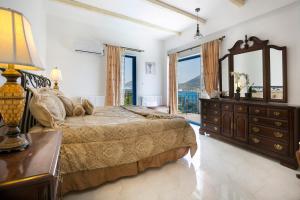 a bedroom with a bed and a dresser and a mirror at Villa Afrodite in Lixouri