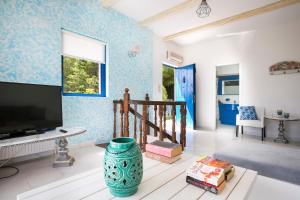 a living room with blue walls and a flat screen tv at Villa Afrodite in Lixouri