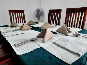 ウダワラウェにあるElegant HomeStayのナプキンと銀食器が置かれたテーブル