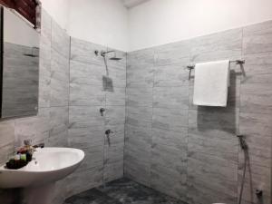 ウダワラウェにあるElegant HomeStayの洗面台とシャワー付きのバスルーム
