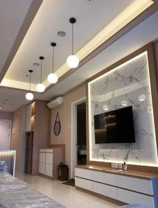 ein Wohnzimmer mit einem Fernseher an der Wand in der Unterkunft Cozy and Luxury place to stay 1BR, Front of Pullman Hotel CP in Mantaak