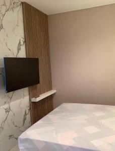 ein Schlafzimmer mit einem Bett und einem Flachbildfernseher in der Unterkunft Cozy and Luxury place to stay 1BR, Front of Pullman Hotel CP in Mantaak