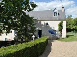 a white house with a blue umbrella in front of it at Gîte familial spacieux avec jardin privé, proche châteaux et zoo, jeux pour enfants, billard et cheminée - FR-1-381-6 in Bléré