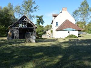 an old barn and a house in a field at Moulin atypique du XVème siècle avec jardin clos - FR-1-381-483 in Arpheuilles