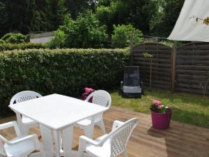 a white table and chairs on a wooden deck at Charmante maisonnette avec cheminée et jardin, proche des châteaux de la Loire - FR-1-381-230 in Montbazon