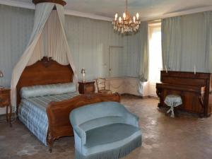 a bedroom with a bed and a chair and a piano at Château Directoire avec Piscine Privée et Jardin - FR-1-381-485 in Châtillon-sur-Indre