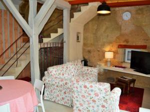 Una sala de estar con un sofá y un televisor. en Gîte atypique troglodytique, calme, proche de la Loire, tout inclus, avec cour privative et garage - FR-1-381-280, en Savonnières