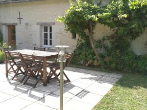 a wooden table and chairs in front of a house at Gîte calme au cœur de vignoble bio avec piscine, proche Azay-le-Rideau - FR-1-381-238 in Brizay