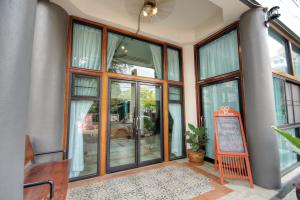 a room with large windows and a sign in it at Saeng Panya Home SHA Plus in Chiang Mai