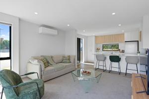 a living room with a couch and a table at Lux Local Living in Christchurch