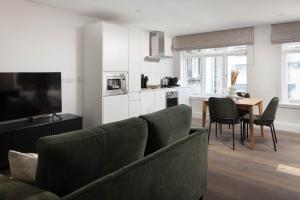 a living room with a couch and a kitchen with a table at Urban Rest Dublin Central in Dublin