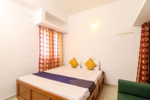 Un pequeño dormitorio con una cama y una silla. en SPOT ON Hotel Om Kanha, en Bilāspur 17 fotos más