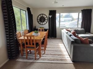 un soggiorno con un tavolo e un divano di Home Comforts on Main a Methven