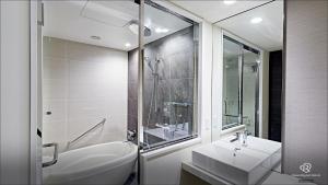 a white bathroom with a sink and a shower at Daiwa Roynet Hotel Kyoto Ekimae PREMIER in Kyoto