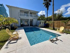 una piscina con dos sillas y una casa en Luxury - Southern Charm Home - Steps from Beach!, en South Padre Island