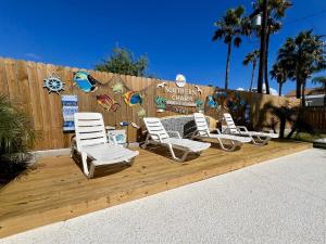 un grupo de sillas sentadas en una terraza de madera en Luxury - Southern Charm Home - Steps from Beach!, en South Padre Island