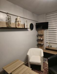 sala de estar con silla blanca y mesa en Luxury Angel Apartments 2, en Paralia Katerinis