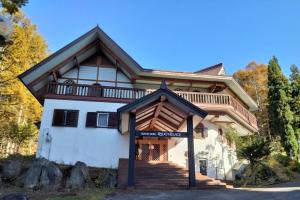 una casa con un balcone in cima di ホテル竜王ヴィレッヂ a Yamanouchi