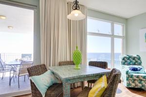 a dining room with a table and chairs with a view of the ocean at Sterling Reef 907 - Brent's Beach in Panama City Beach